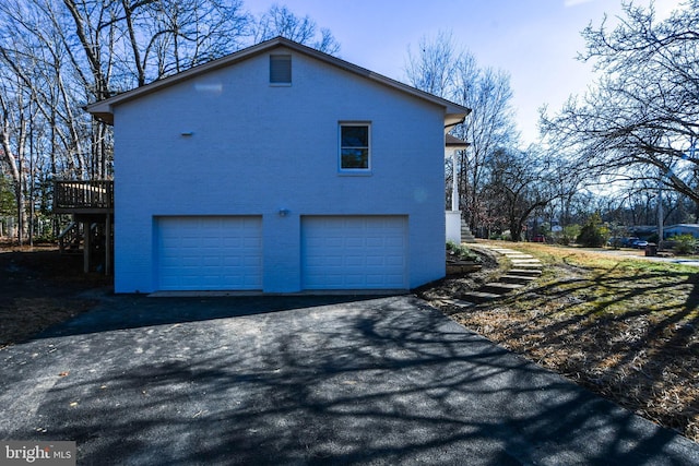 view of side of home with a garage and a wooden deck