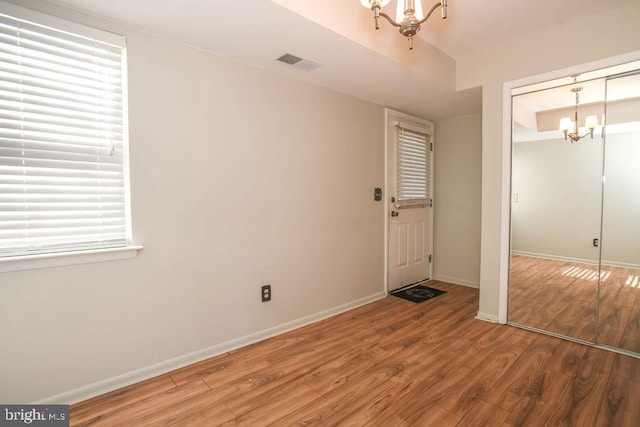 entrance foyer featuring a notable chandelier and wood-type flooring