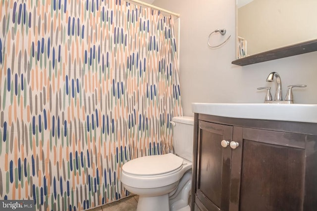 bathroom featuring tile patterned floors, vanity, and toilet