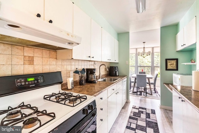 kitchen with sink, white gas range oven, light wood-type flooring, a notable chandelier, and white cabinetry