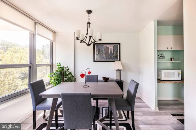 dining area featuring light hardwood / wood-style flooring and a chandelier