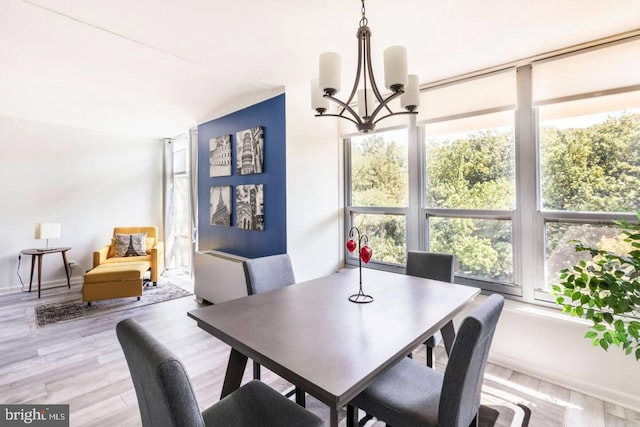 dining space with a chandelier and light hardwood / wood-style flooring