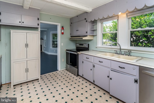 kitchen with beamed ceiling, appliances with stainless steel finishes, and sink