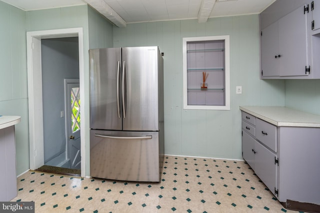 kitchen with stainless steel refrigerator and wooden walls