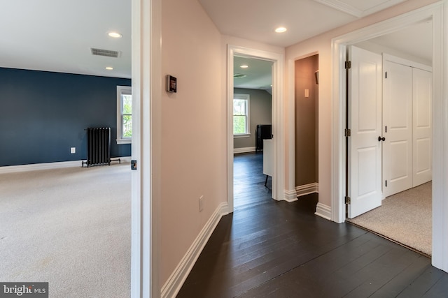 corridor featuring radiator and dark colored carpet