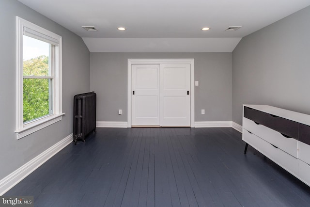 interior space with dark wood-type flooring, radiator, and lofted ceiling