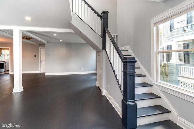 staircase with hardwood / wood-style flooring, ornate columns, and ceiling fan