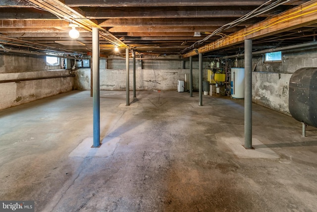 basement featuring a wealth of natural light and water heater