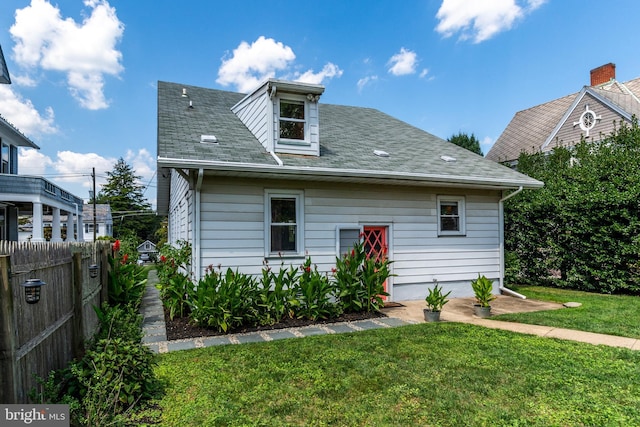 rear view of house featuring a lawn