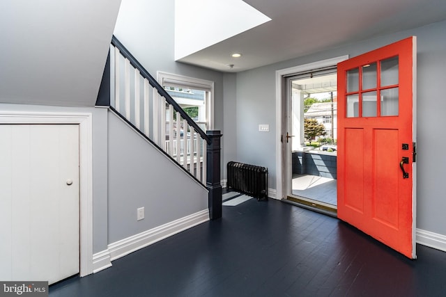 entrance foyer featuring radiator, plenty of natural light, and dark wood-type flooring