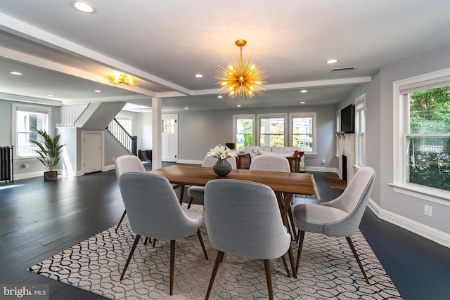 dining room featuring dark hardwood / wood-style flooring, a wealth of natural light, and an inviting chandelier