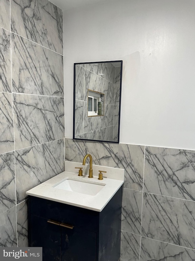 bathroom featuring vanity and tile walls