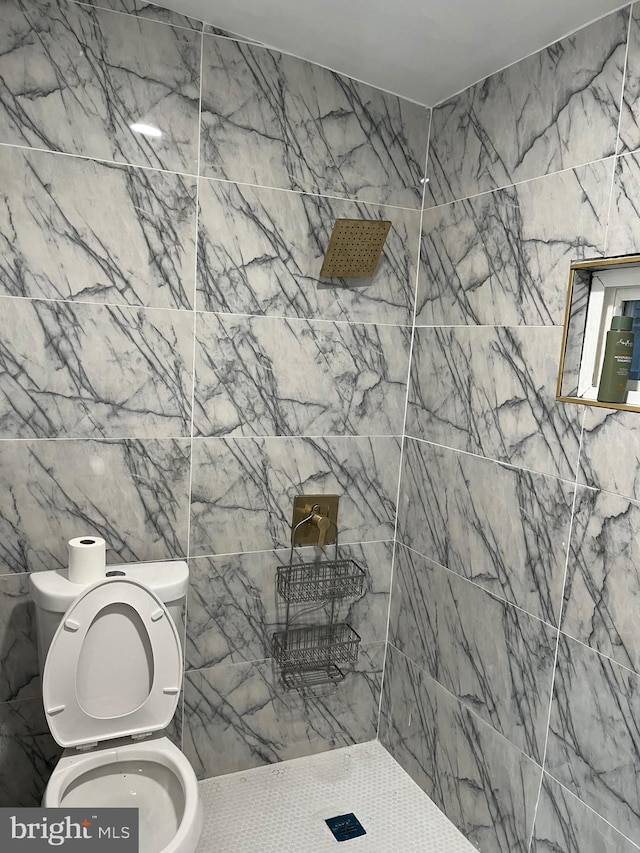 bathroom with toilet and a tile shower