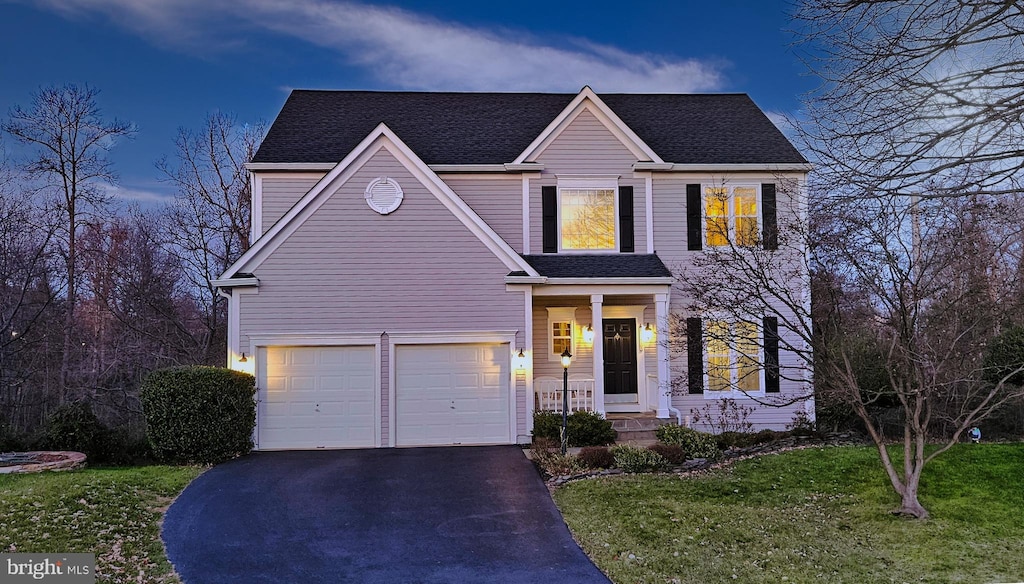 view of front of home with a garage and a lawn