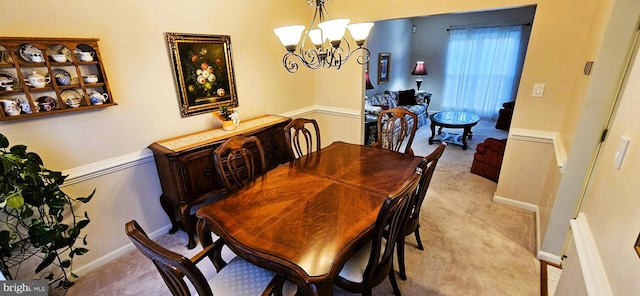 carpeted dining area with an inviting chandelier