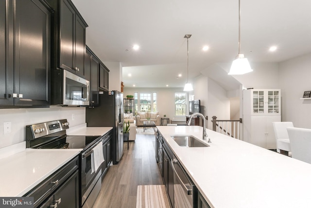 kitchen featuring pendant lighting, dark hardwood / wood-style flooring, sink, and appliances with stainless steel finishes