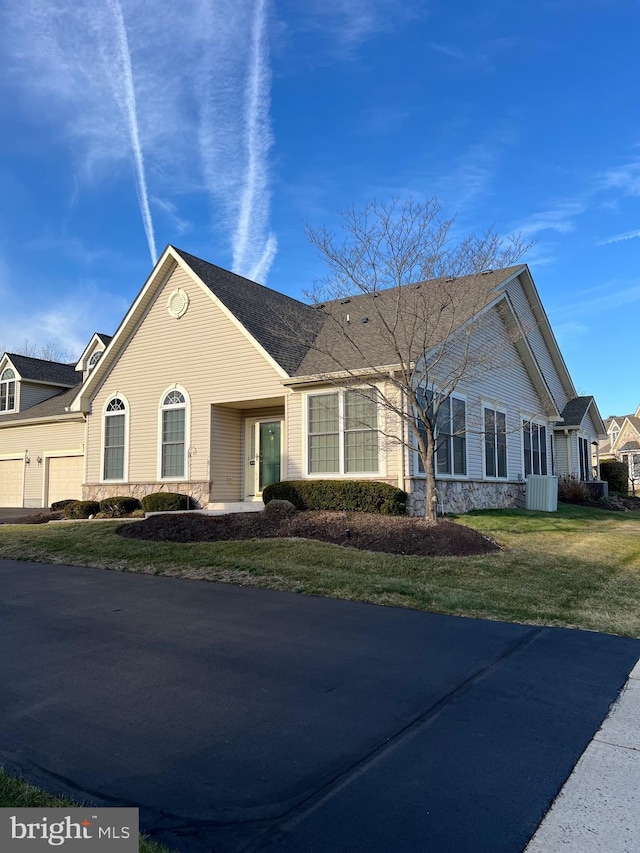 view of side of home featuring a lawn and a garage