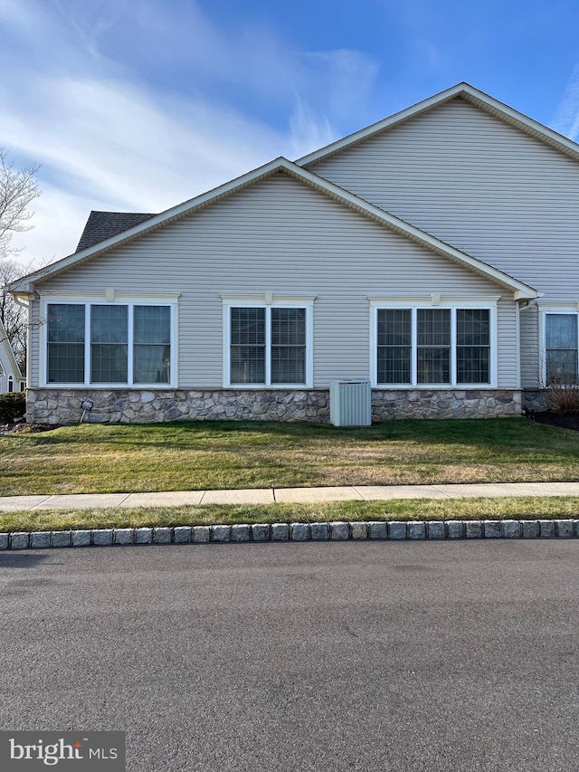 view of property exterior featuring a yard and central AC