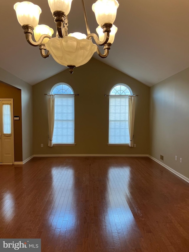 unfurnished room with a chandelier, vaulted ceiling, and dark wood-type flooring