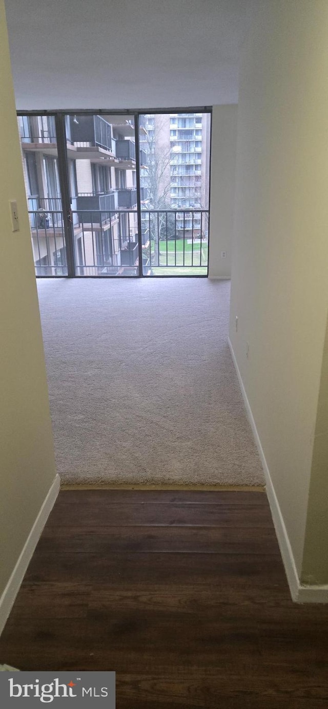 hall featuring dark colored carpet