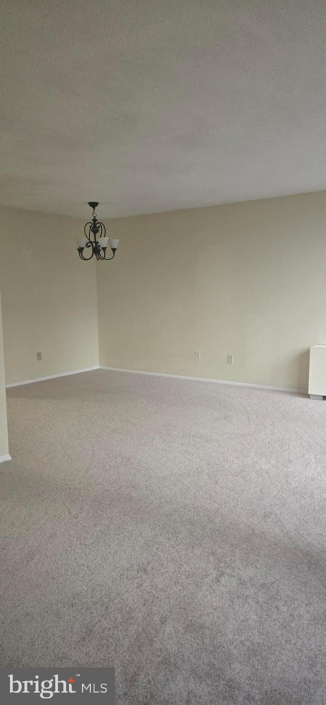 spare room with a chandelier and a textured ceiling