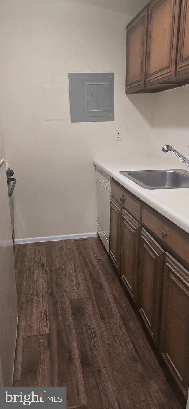 kitchen featuring dark hardwood / wood-style floors, white dishwasher, electric panel, dark brown cabinetry, and sink