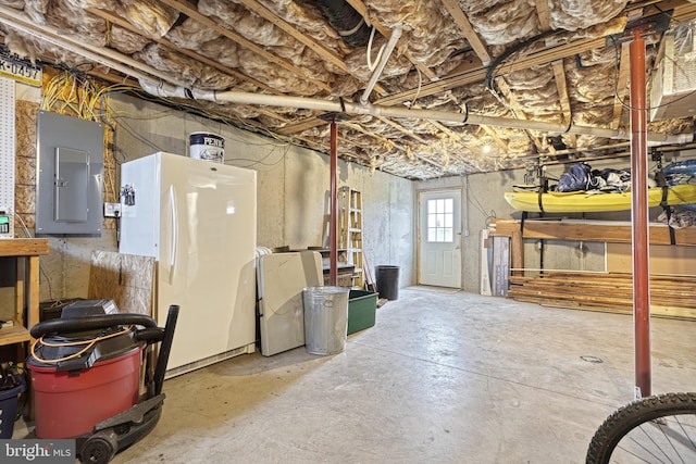 basement with electric panel, refrigerator, and white fridge