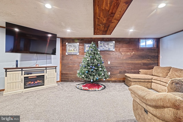 carpeted living room featuring a textured ceiling and wooden walls