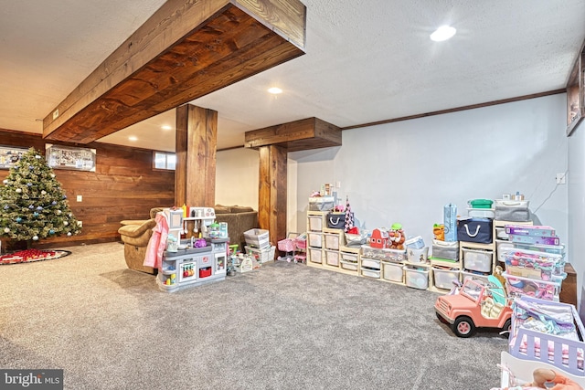 game room with carpet flooring, a textured ceiling, and wooden walls