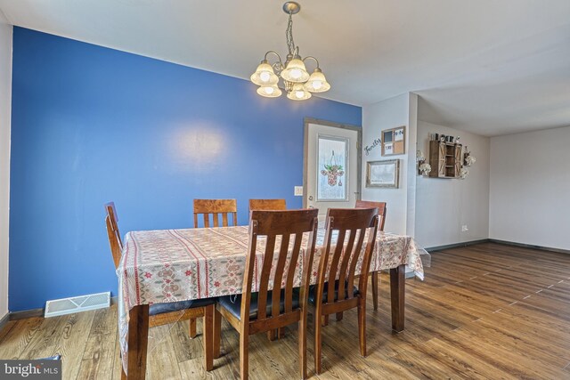 dining area featuring hardwood / wood-style flooring and a chandelier