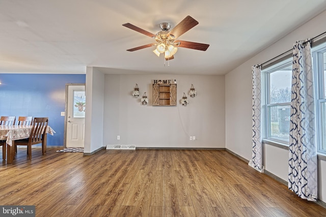 interior space featuring ceiling fan, a healthy amount of sunlight, and wood-type flooring