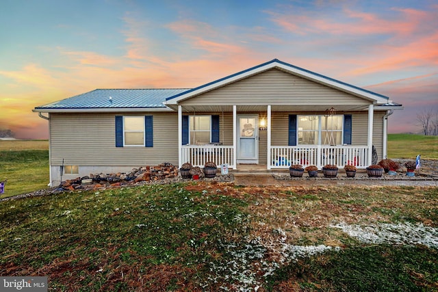 view of front of property with covered porch and a yard