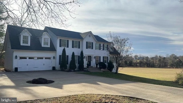 colonial inspired home with a front yard and a garage