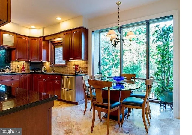 kitchen with sink, decorative light fixtures, a notable chandelier, and tasteful backsplash