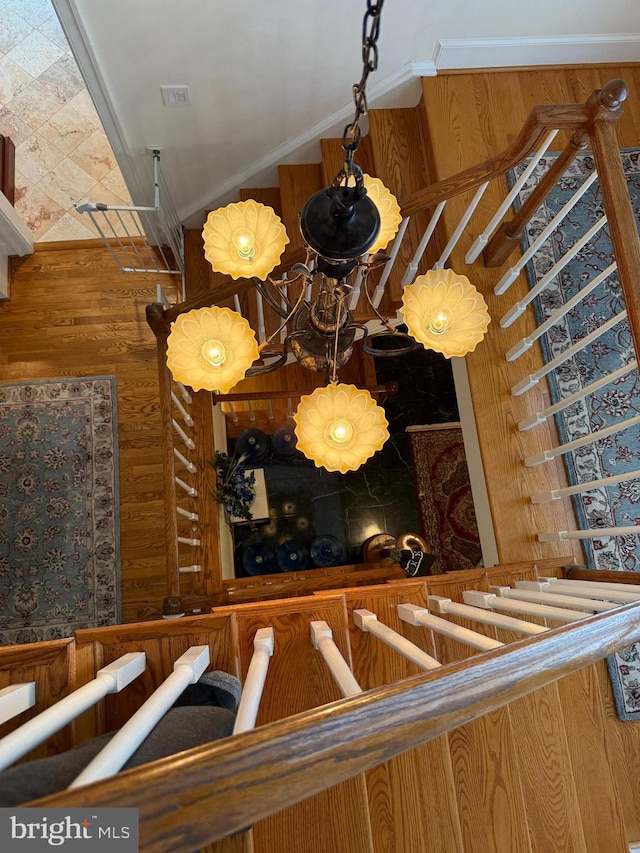 interior space featuring ornamental molding and wood walls