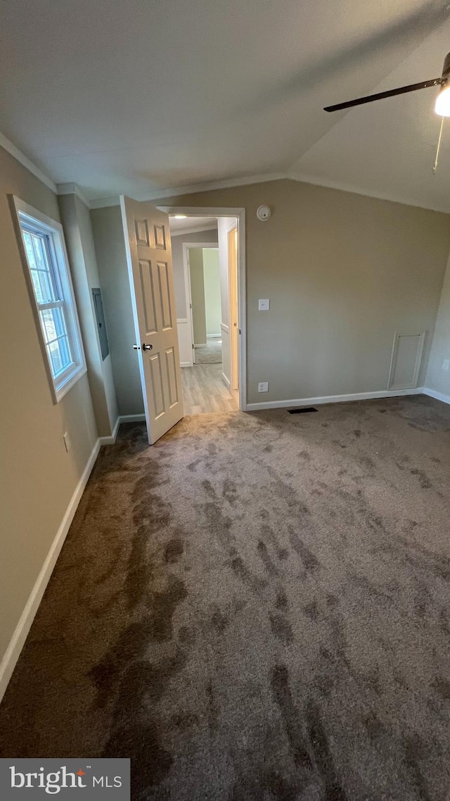 unfurnished room featuring visible vents, baseboards, vaulted ceiling, ornamental molding, and carpet