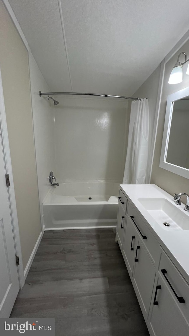 full bathroom featuring shower / bath combo with shower curtain, vanity, a textured ceiling, and wood finished floors