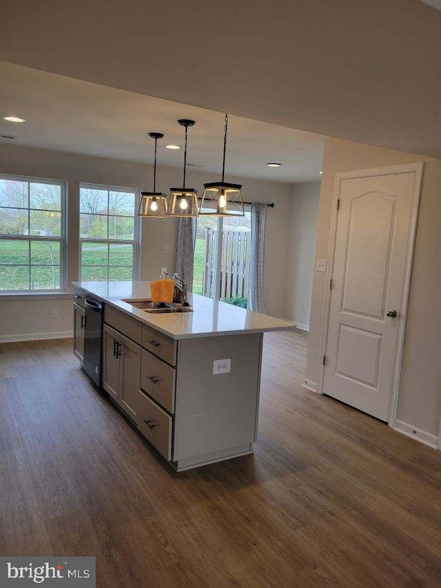 kitchen with a center island, sink, hanging light fixtures, dark hardwood / wood-style floors, and black dishwasher