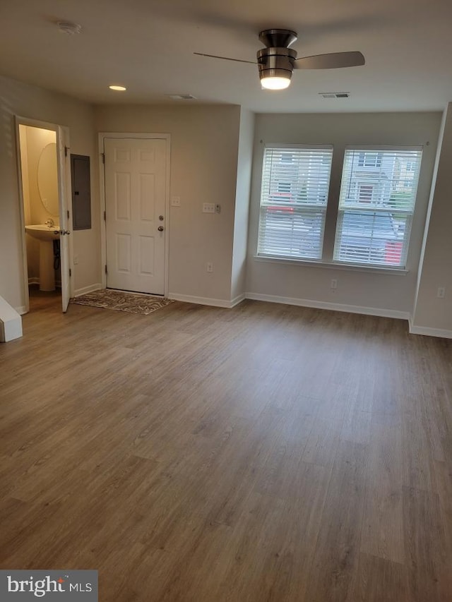 interior space featuring hardwood / wood-style floors, electric panel, ceiling fan, and sink