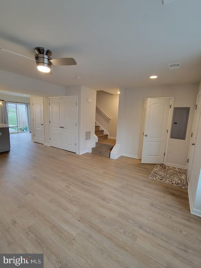 interior space with ceiling fan, light hardwood / wood-style floors, and electric panel