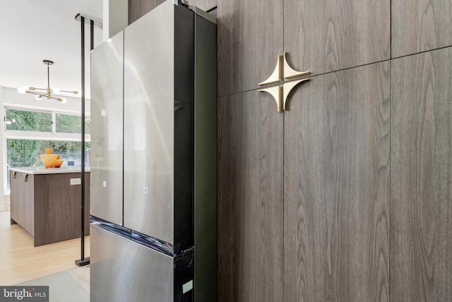 details with stainless steel fridge and wood-type flooring