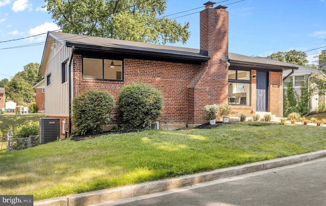 view of front of home with central AC and a front yard