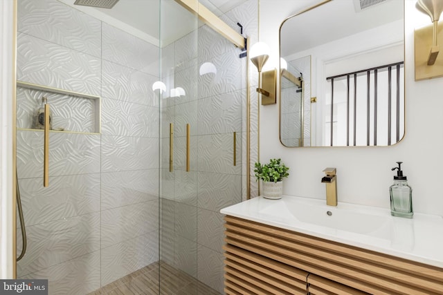 bathroom featuring a tile shower and vanity