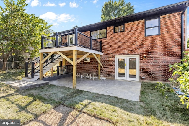 rear view of property with french doors, a patio, a yard, and a wooden deck