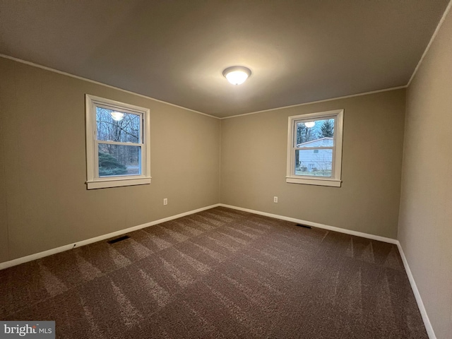 spare room with dark carpet and ornamental molding