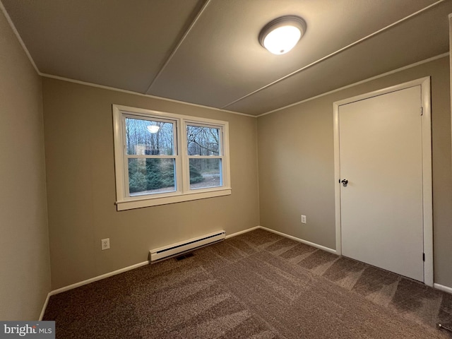 spare room with carpet flooring and a baseboard heating unit