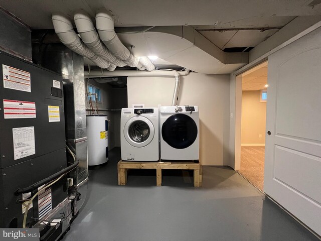 laundry area with heating unit, separate washer and dryer, and water heater