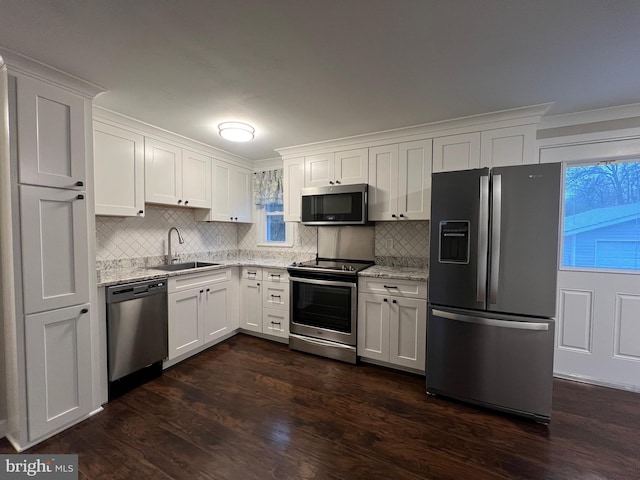 kitchen featuring light stone counters, sink, white cabinetry, and stainless steel appliances