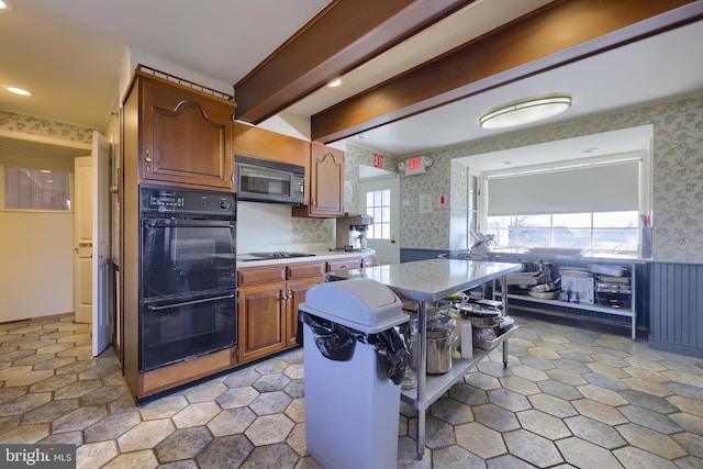 kitchen with a breakfast bar area and black appliances