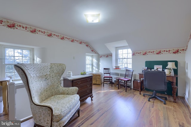 office featuring lofted ceiling and light hardwood / wood-style flooring